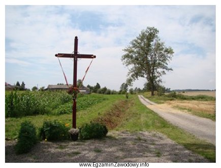 W analizie kompozycyjnej krajobrazu przedstawionego na fotografii przydrożny krzyż 